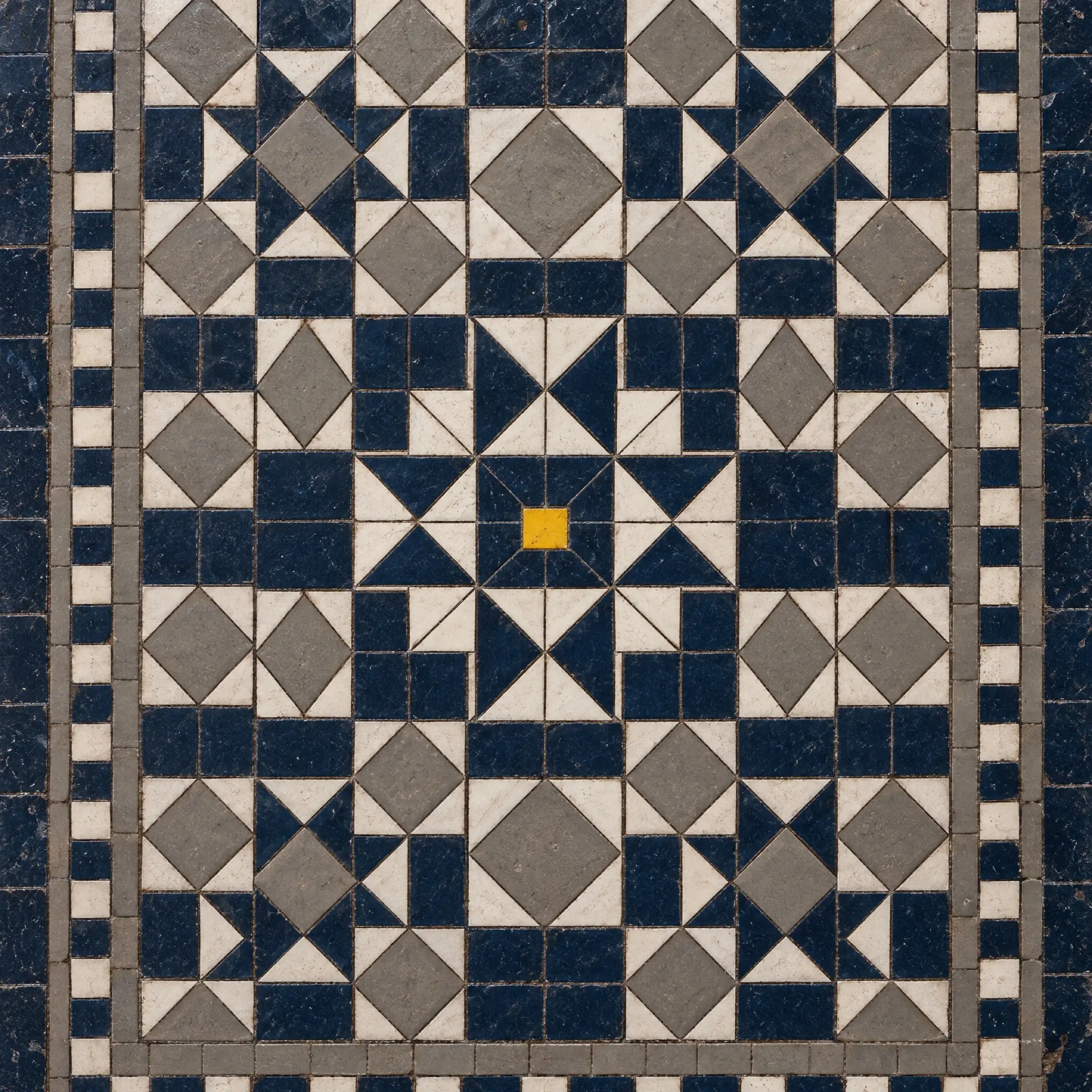 A Victorian mosaic floor in navy, white and grey, with a single yellow tile at its centre.